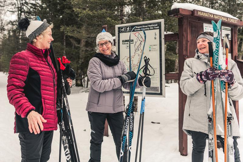3 people holding cross country skis at Rapid River Ski Trail