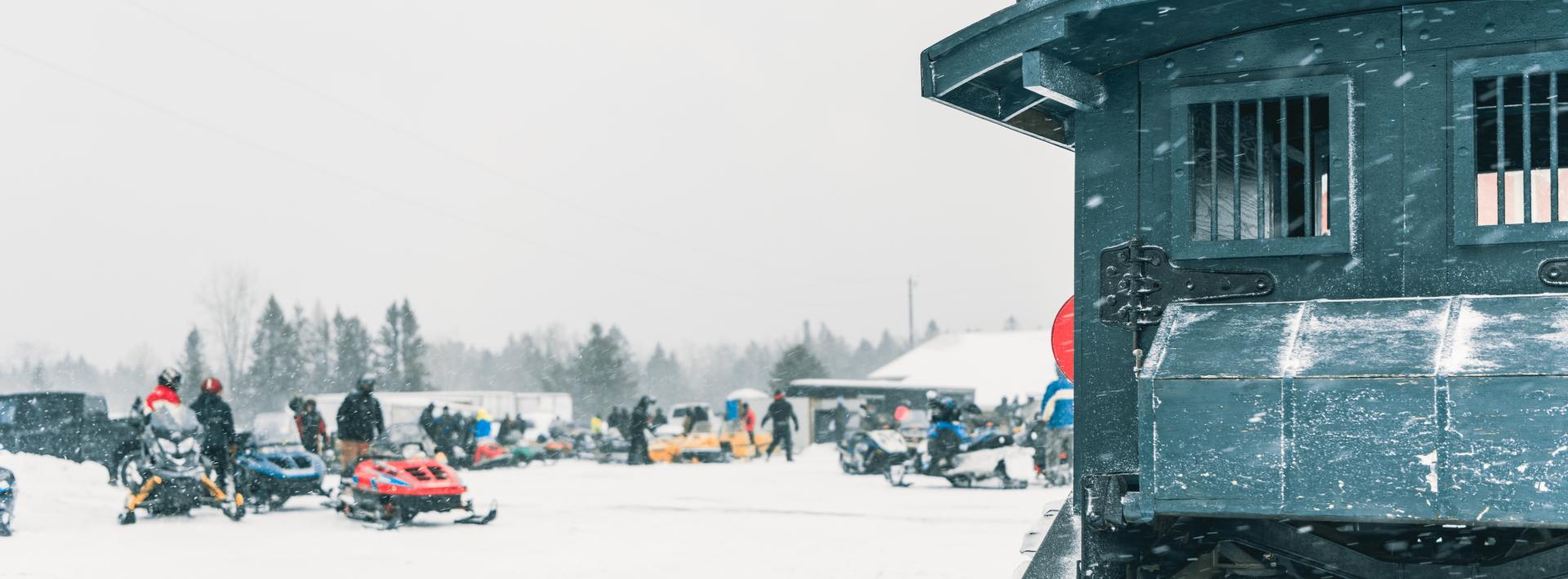  "The header image for the Rapid River Relic Ride captures the essence of this vintage snowmobiling event, featuring a montage of classic snowmobiles against a snowy landscape.