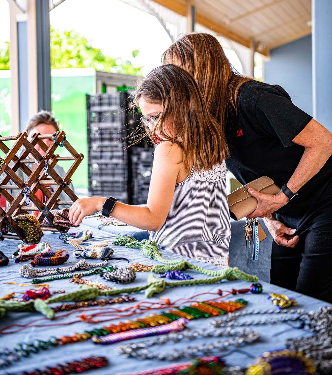 A mother and child at an outdoor market.