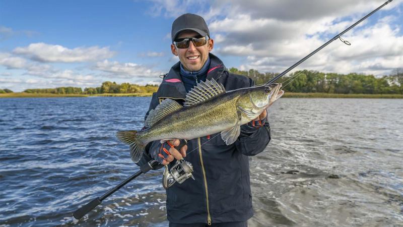 A fisherman holding a walleye.