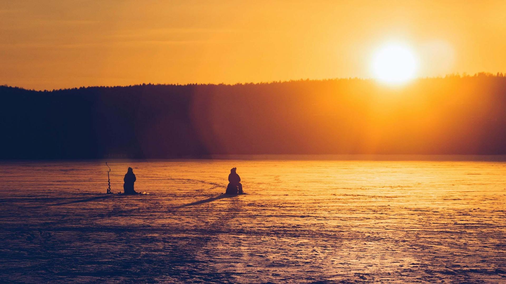 Ice fishing at sunset.