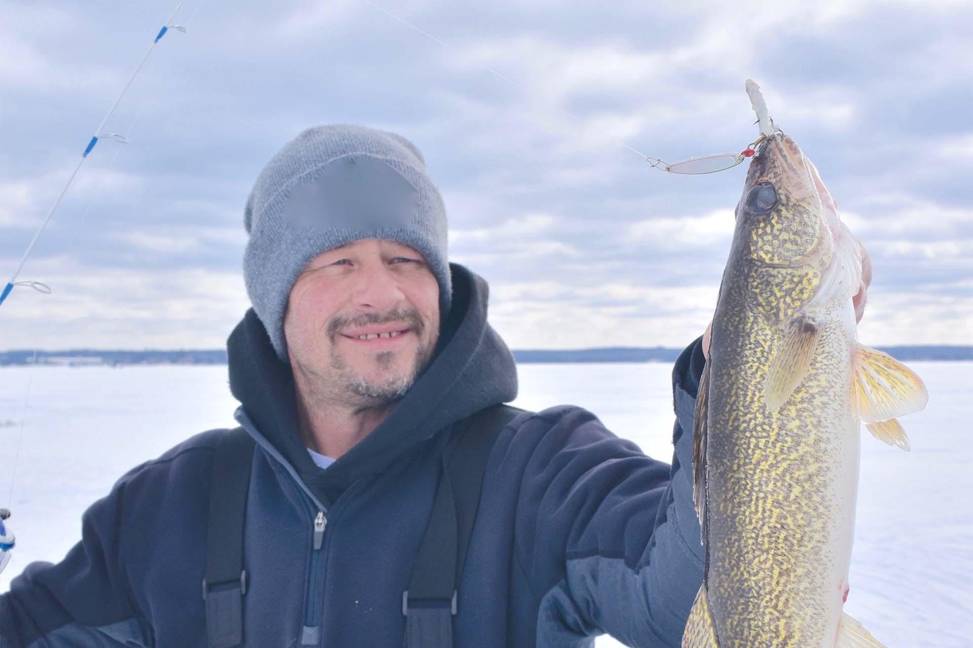 A man holding up a walleye.