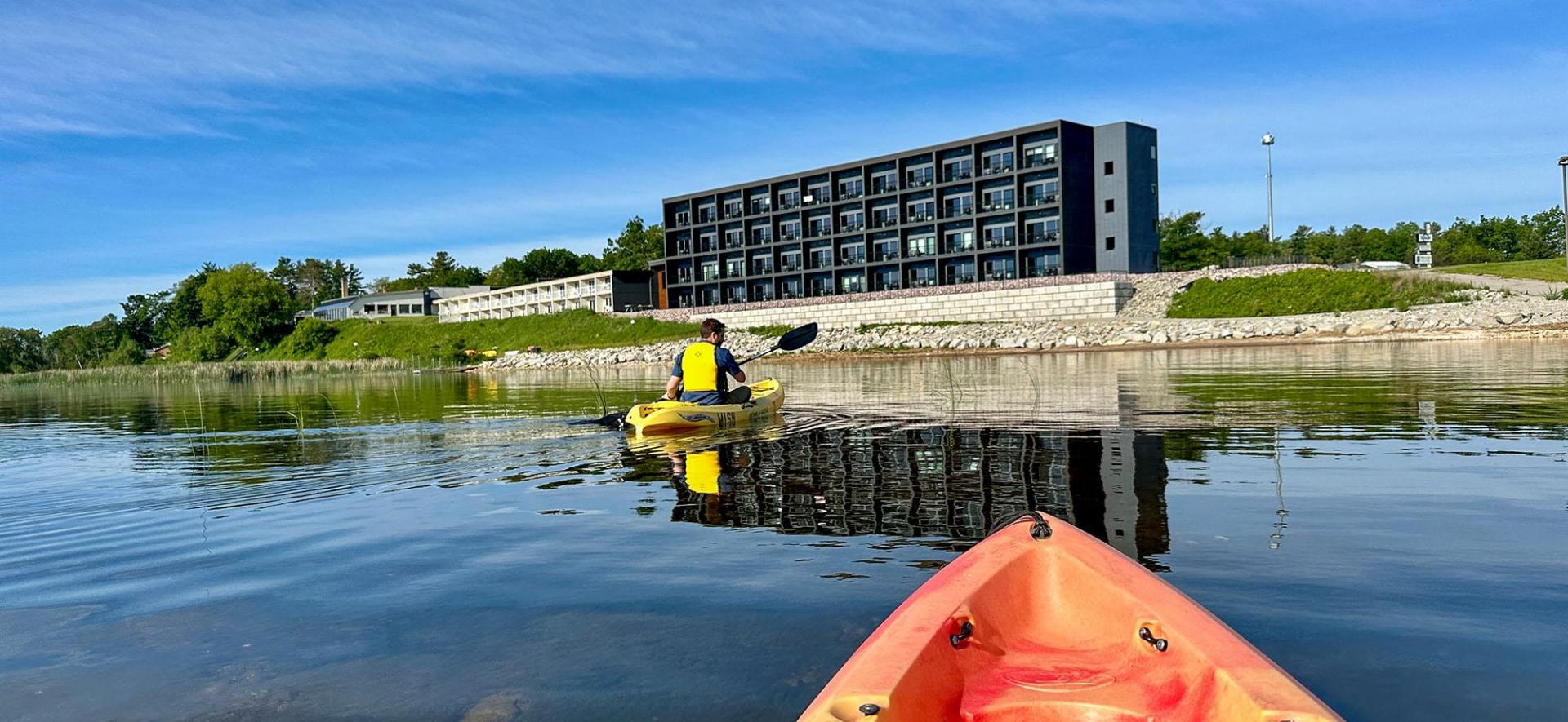 People kayaking in front of Terrace Bay Hotel.