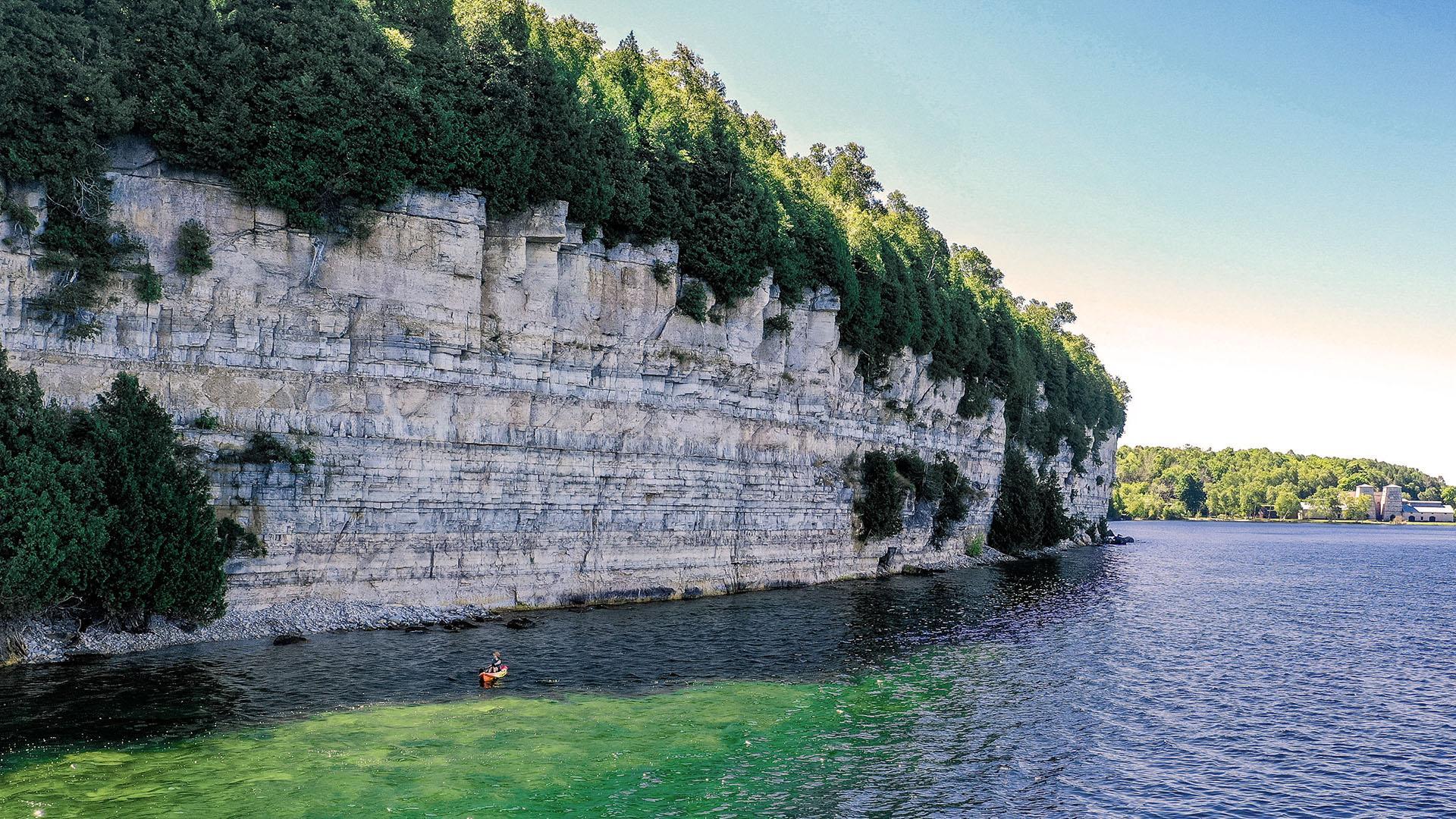A person kayaking near the cliff at Fayette Historic State Park.