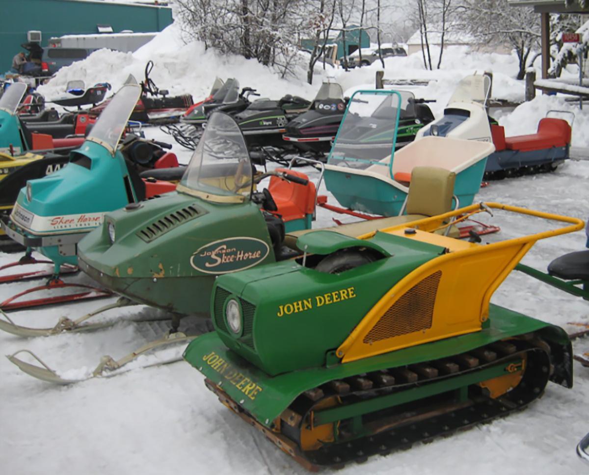 Antique snowmobiles lined up outside during the Rapid River Relic Ride.
