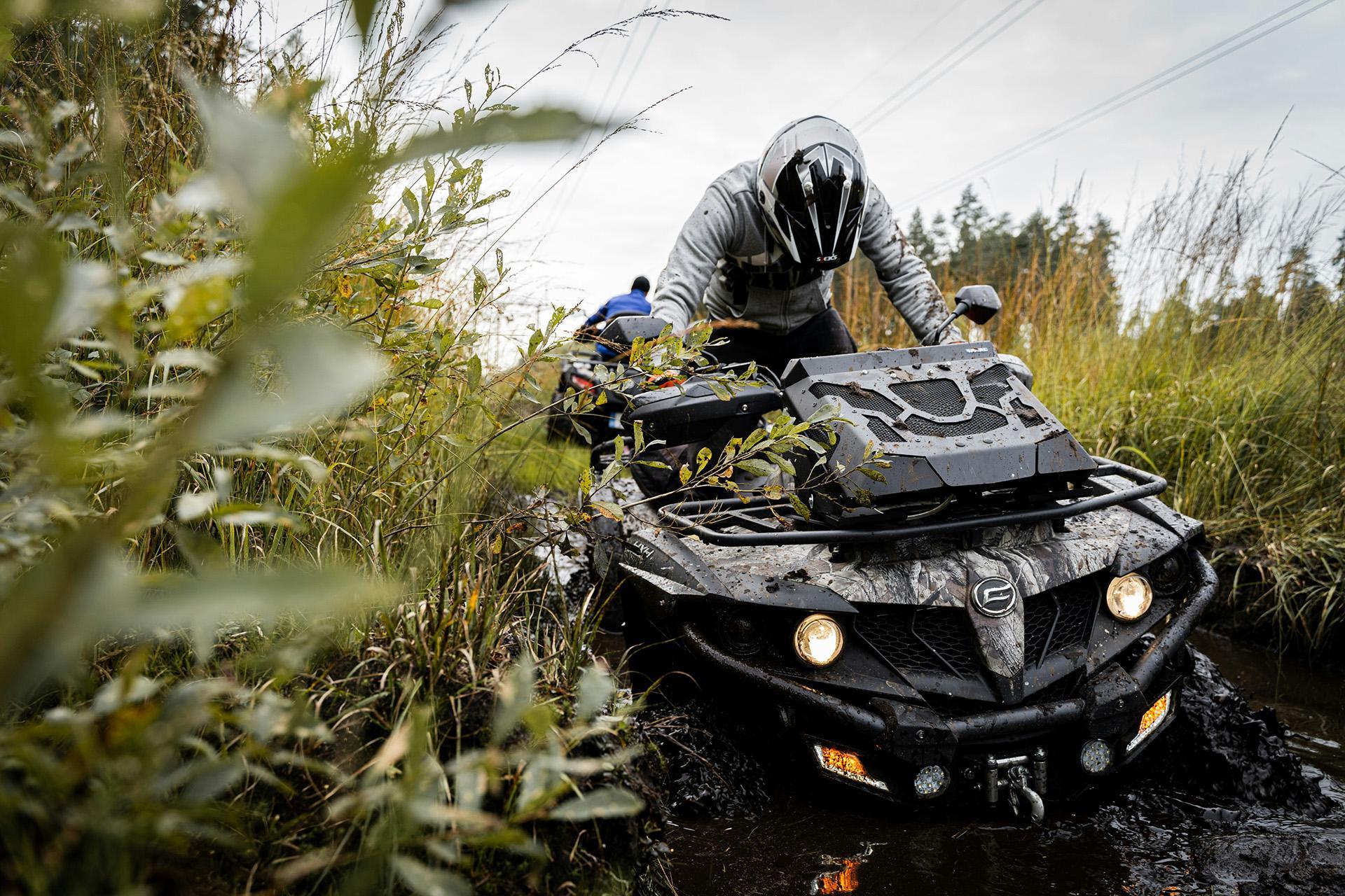 Riders on ATVs travel across the landscape in spring.