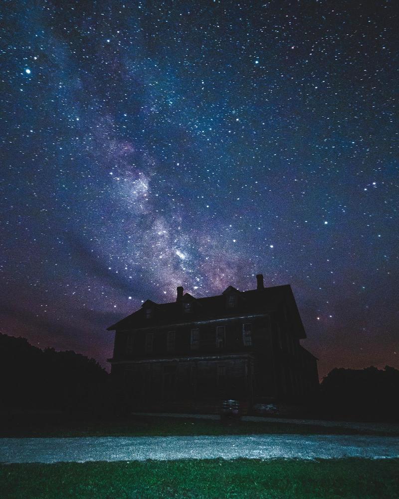 The Milky Way stretches across the night sky above a historic building.