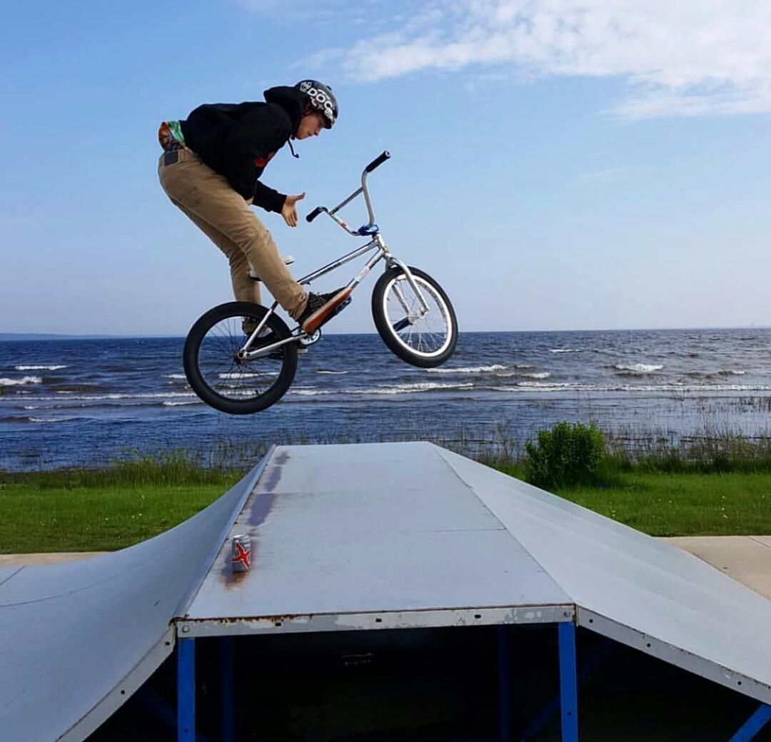 boy doing trick on bike in skate park