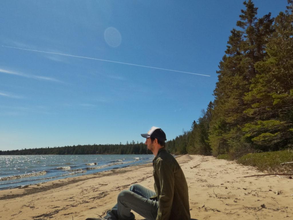 man sitting in sand at a beach