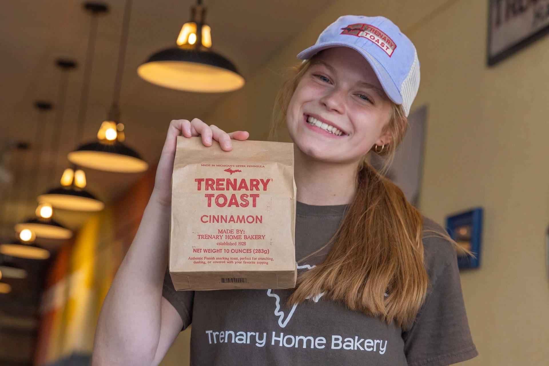 A Trenary Home Bakery worker holding up a bag of Trenary Toast.