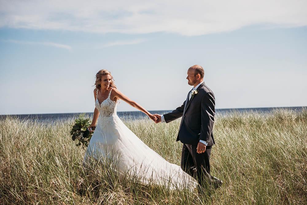 Wedding day couple walking down Escanaba beach