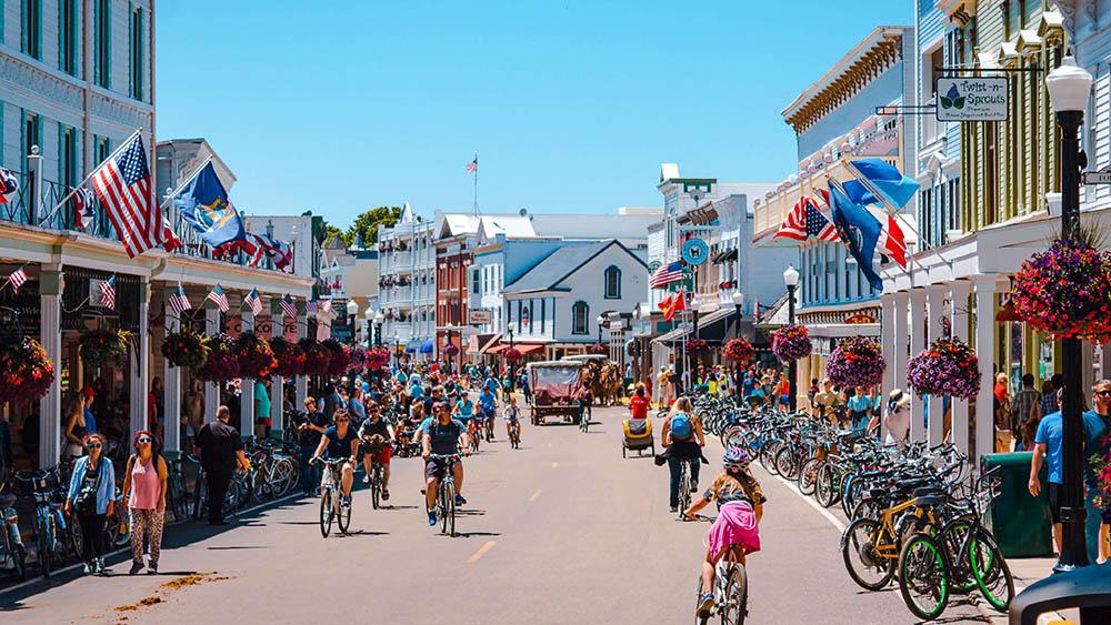 People biking and walking through Mackinac Island.