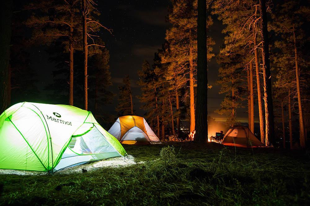 Tents lit up with a campfire in the background at Fayette Historic State Park.